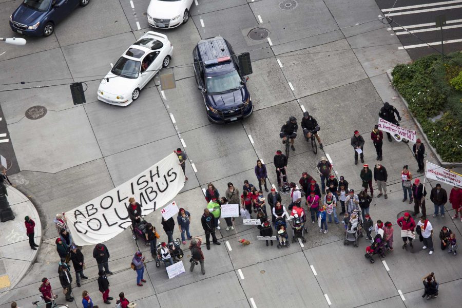 Seattle, Washington, USA - October 12, 2014: Protesters block the 4th Avenue downtown corridor street in Seattle, holding a large sign, in protest against Christopher Columbus and the establishment of Columbus Day. Getty Images.