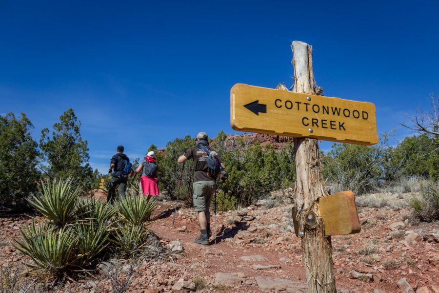 a group of backpackers walk past a sign that says cottonwood creek