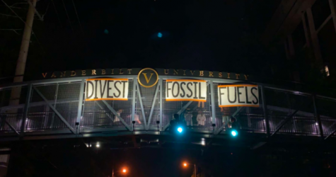 Student activists hang signs on the Commons Bridge demanding divestment. (Photo courtesy of Dores Divest)