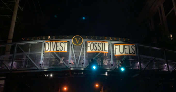 Student activists hang signs on the Commons Bridge demanding divestment. (Photo courtesy of Dores Divest)