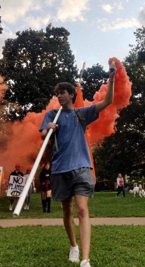 student holds orange smoke bomb
