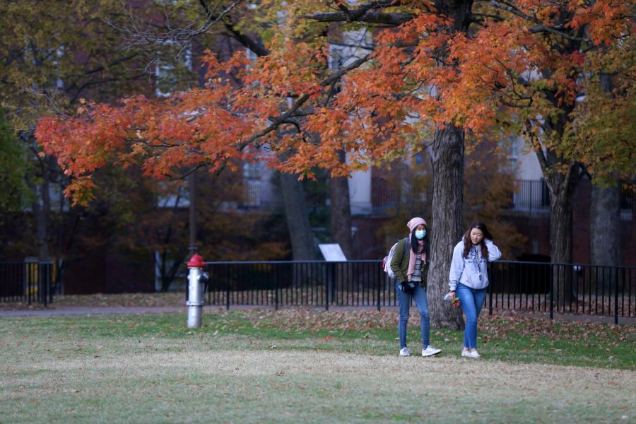 A student wears a mask while walking across campus with a peer. (Hustler Multimedia/Hallie Williams)