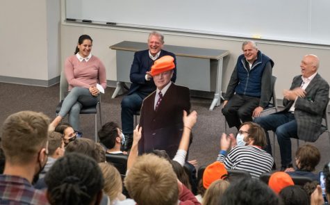 Cutout of Al Gore dressed in Dores' Divest signature orange beanies with Gore seen in the background