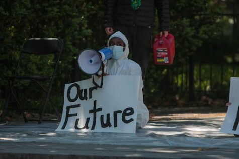 Ruth Aklilu at a Dores Divest protest, holding a handwritten sign that states “Our Future"