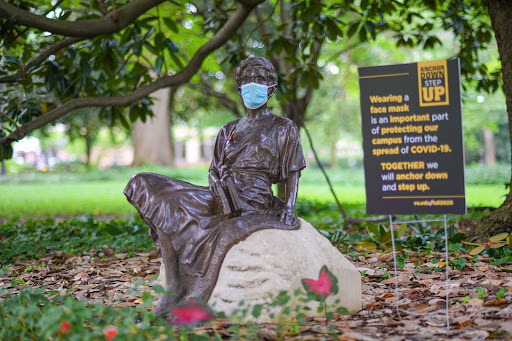 A statue on campus wearing a mask next to an “Anchor Down, Step Up” sign, photographed on Sept. 3, 2020. (Hustler Multimedia/Truman McDaniel)