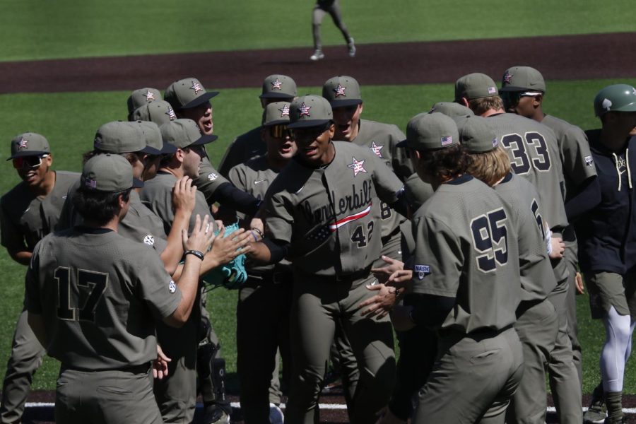 Vanderbilt huddles to congratulate pitcher Christian Little in a game against Tennessee on April 3, 2022.