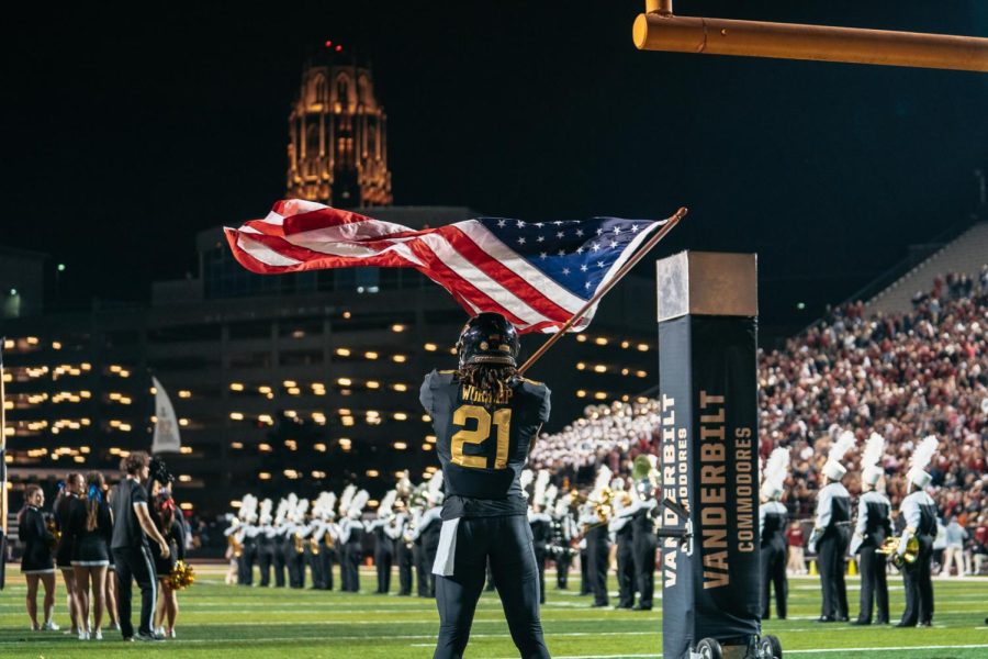 Maxwell Worship hoists aloft the American Flag as the team prepares to enter the stadium, as photographed on Nov. 5, 2022. (Hustler Multimedia/Arianna Santiago)