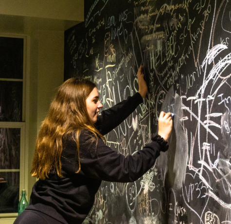 Student adds to the chalkboard wall in North House during the signature event, SNorthasborg, as captured on Nov. 16, 2022. (Hustler Multimedia/Laura Vaughan)