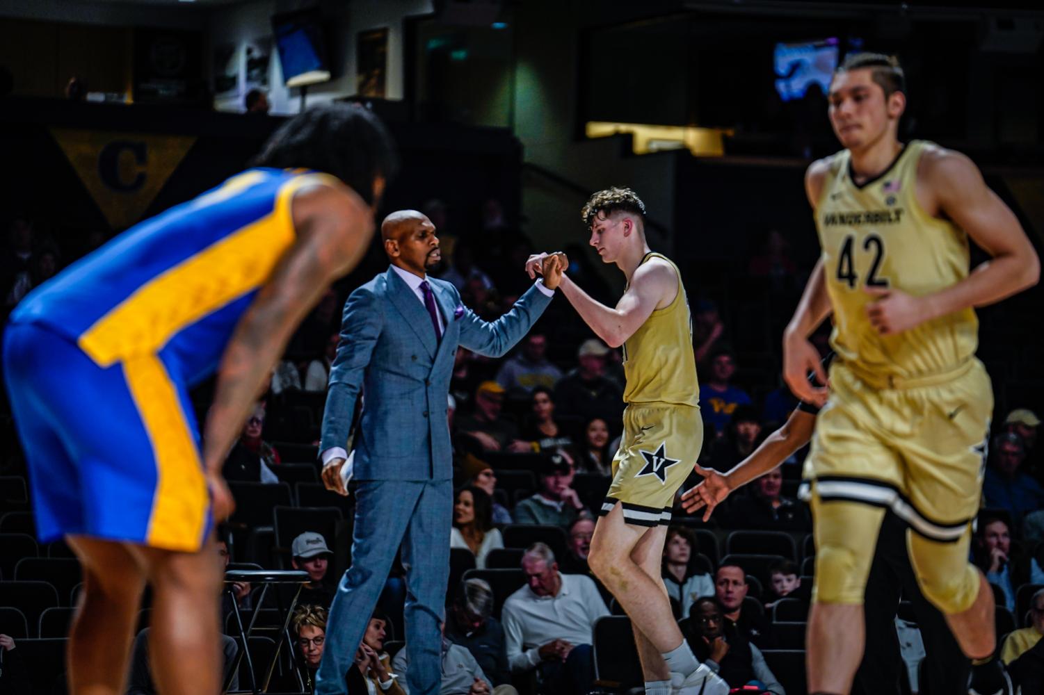Liam Robbins and head coach Jerry Stackhouse fist bump as Robbins checks out of the game against Pitt on Dec. 7, 2022. (Hustler Multimedia / Miguel Beristain)