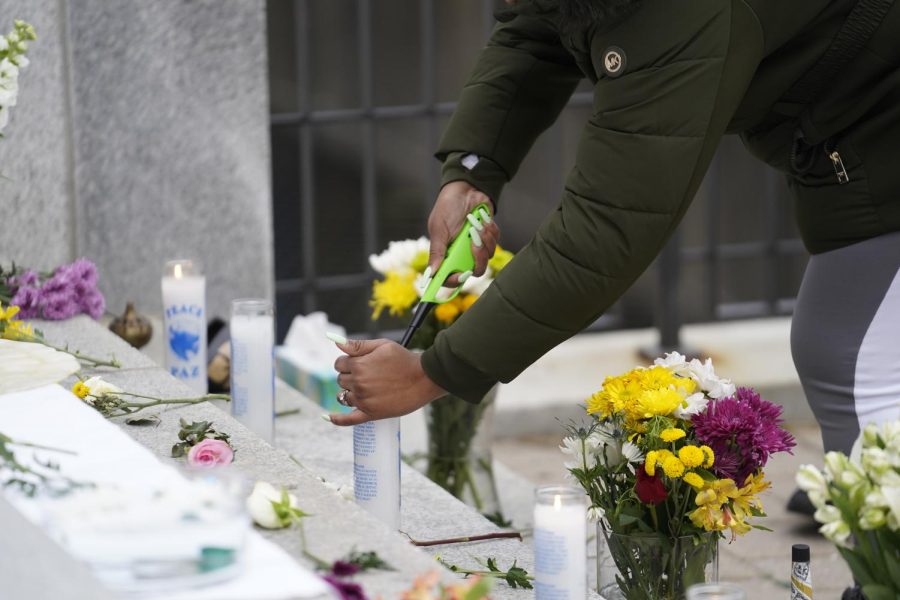 Vigil attendee lights a candle on the steps of the Municipal Courthouse, as photographed on Feb. 4 (Hustler Multimedia/Nikita Rohila).