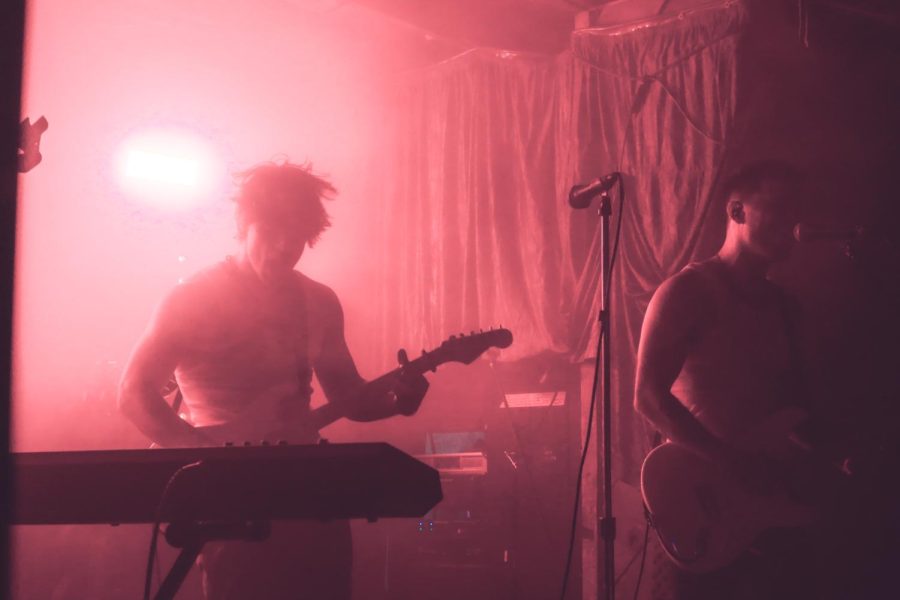 Struan and guitarist Jeremy Vogel perform on a crimson-lit stage, as photographed on June 30, 2023. (Hustler Multimedia/Chloe Kim)