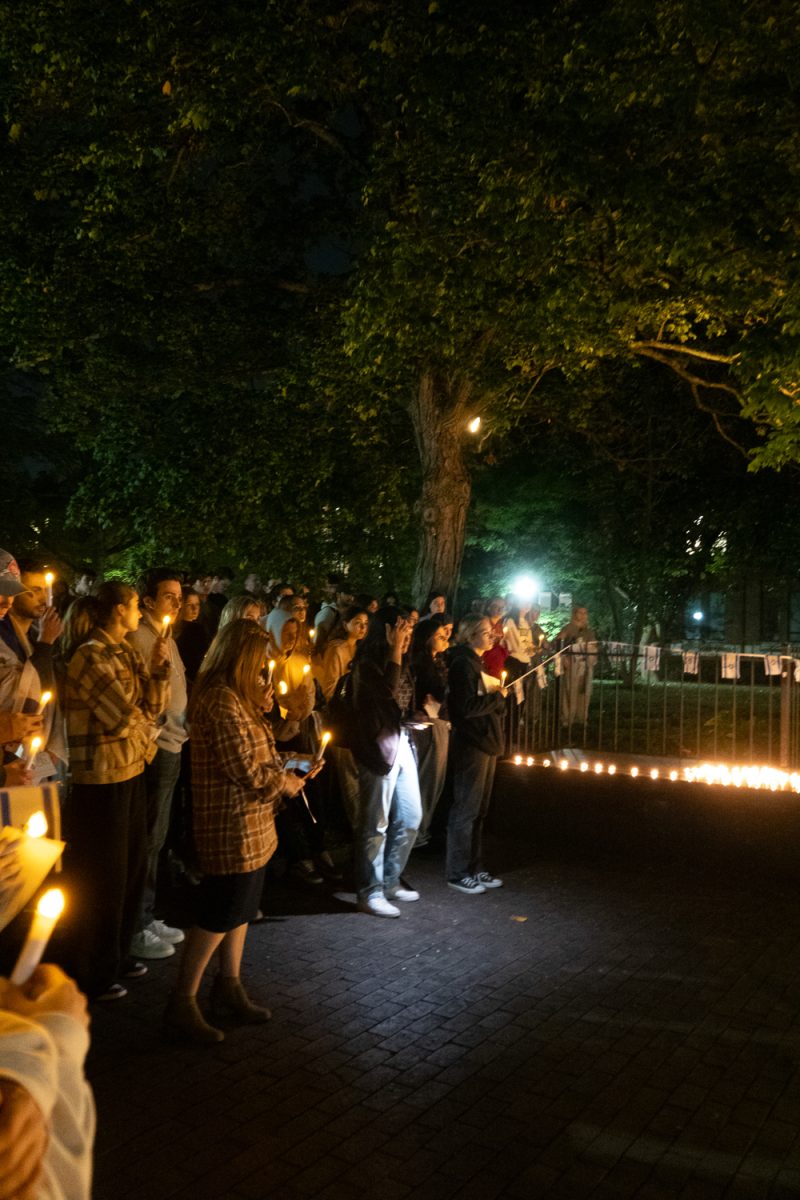 Students and community members hold lit candles as they listen to speakers at the vigil, as photographed on Oct. 10, 2023. (Hustler Multimedia/Charlotte White)
