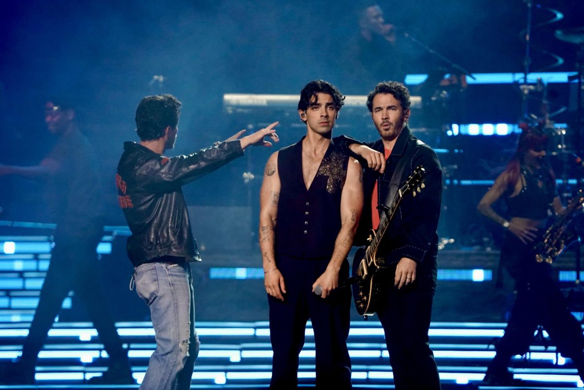 Kevin and Joe Jonas of the Jonas Brothers look into the crowd while Nick holds his arms out toward them, as photographed on Oct. 9, 2023. (Hustler Multimedia/Sara West)