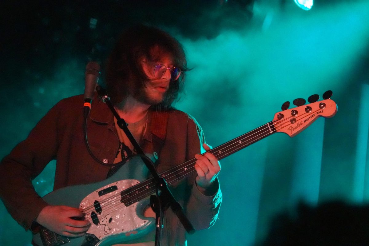 Band member Ian Farmer plays bass guitar in blue light, as photographed on Nov. 11, 2023. (Hustler Multimedia/Payton Ohler)