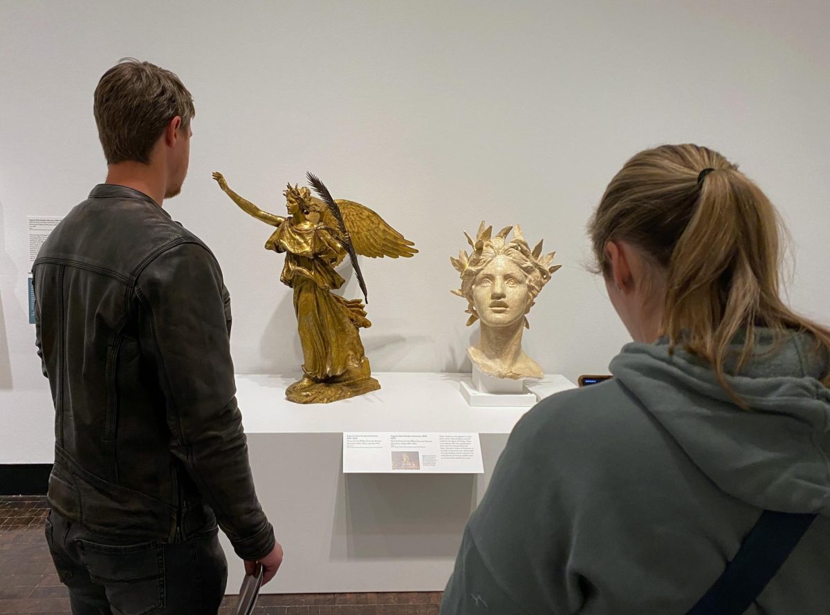 Two sculptures on exhibit at the Frist in between two subjects in the foreground, as photographed on March 2, 2024. (Hustler Multimedia/George Albu)
