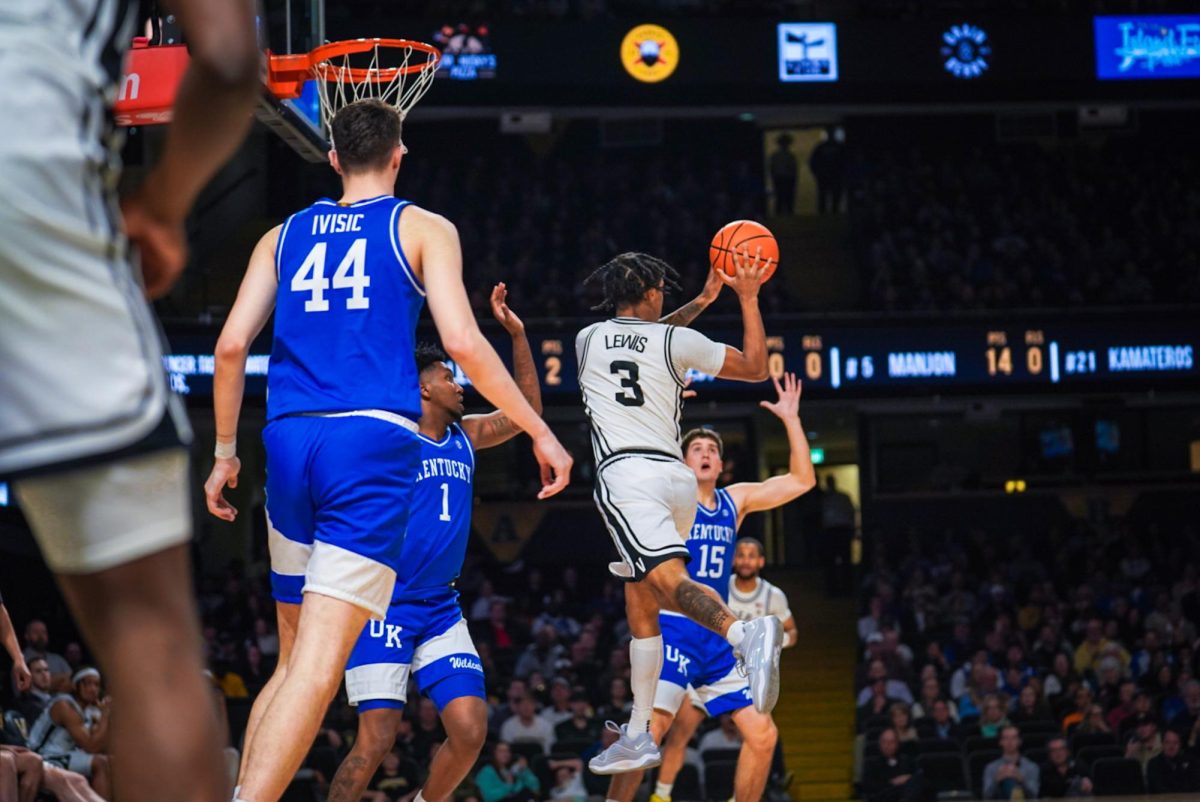 Paul Lewis passes the ball while surrounded by Kentucky defense, as photographed on Feb. 6, 2024. (Hustler Multimedia/Nikita Rohila)