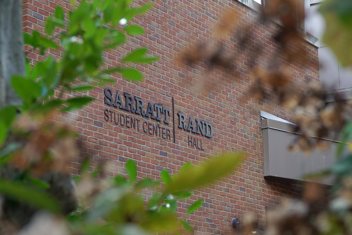 Sarratt Student Center and Rand Hall sign captured through fall foliage, as photographed on Oct. 26, 2023. (Hustler Multimedia/Abby Hoelscher)