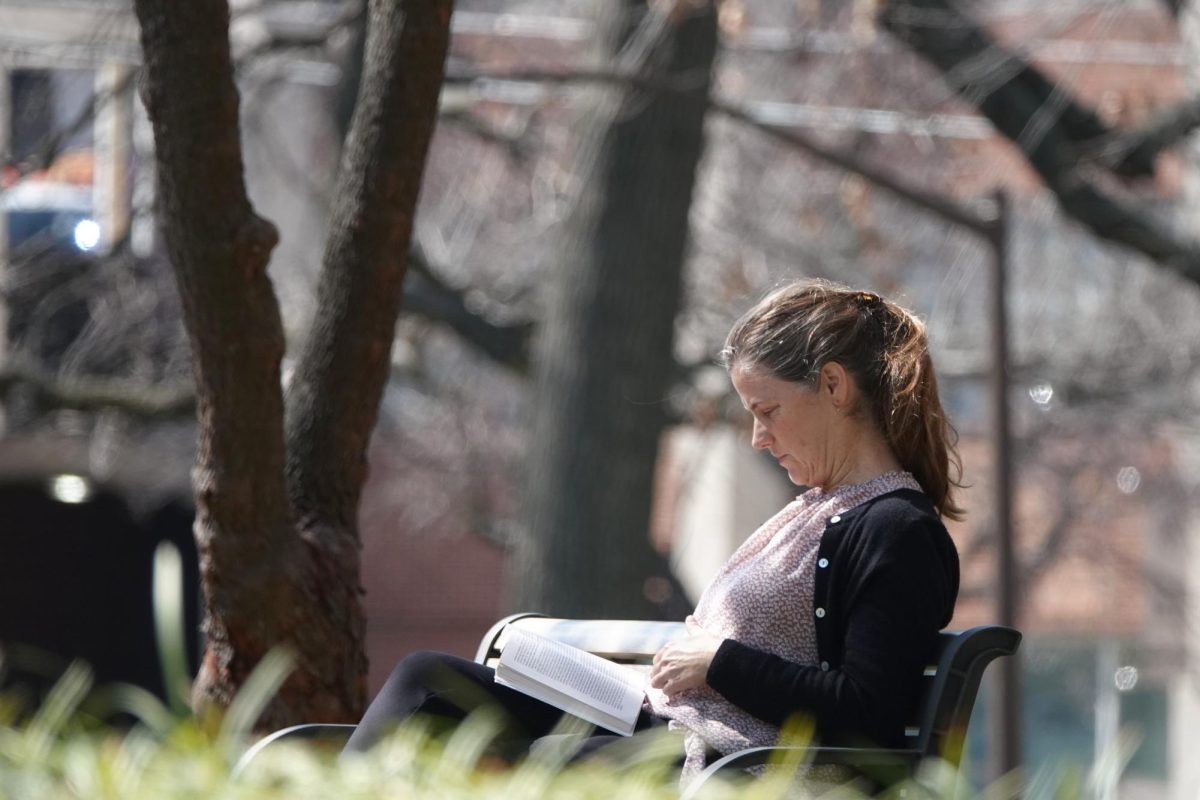 Person reads on a bench on Peabody Campus, as photographed on March 4, 2024. (Hustler Multimedia/George Albu)