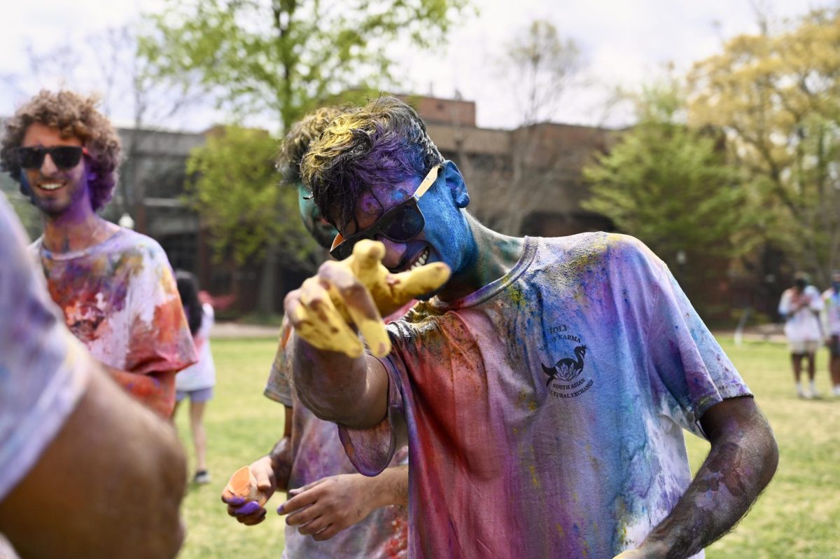 Student points to camera while covered in colorful powder to celebrate Holi, as photographed on March 31, 2024. (Hustler Multimedia/Alysa Suleiman)
