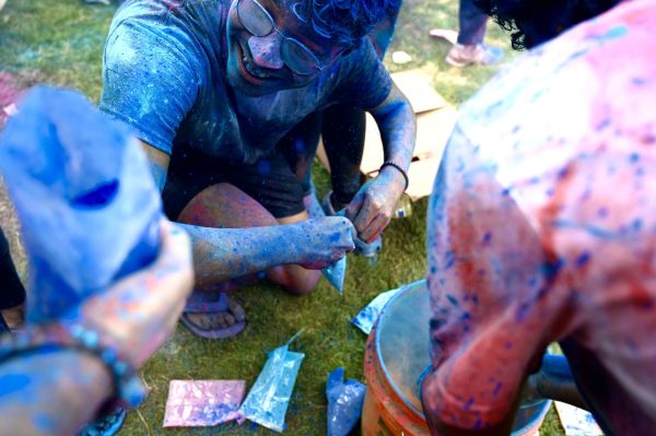Student opens a bag of colorful powder to celebrate Holi, as photographed on March 31, 2024. (Hustler Multimedia/Alysa Suleiman)