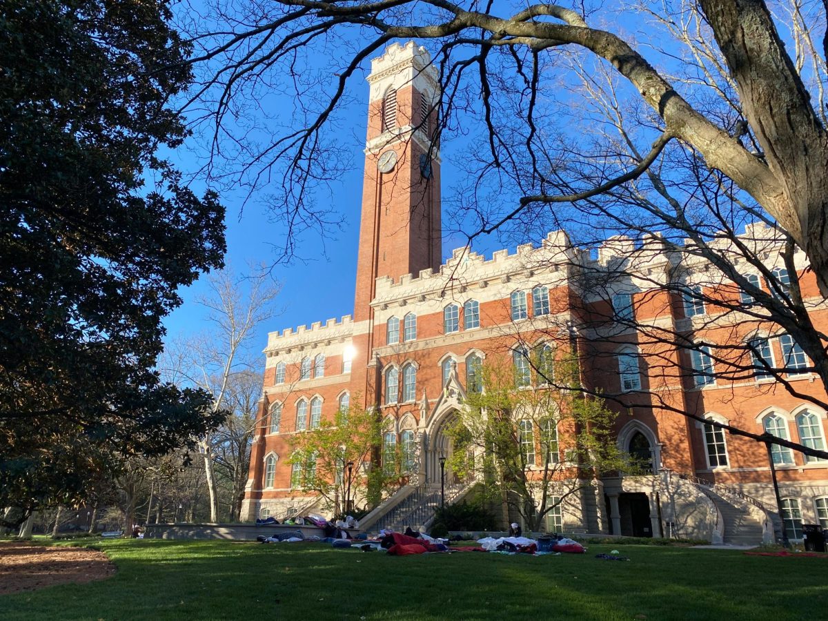 Photograph of Kirkland Hall on a sunny day with individuals lying on the lawn in front of it, as photographed on March 27, 2024. (Hustler Multimedia/George Albu)