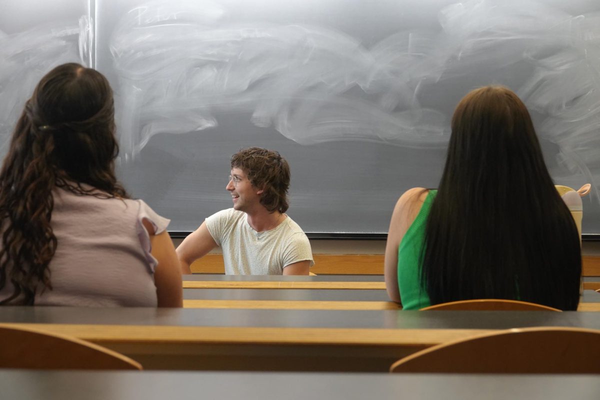 Daniel Nunnelee sits in front of a Buttrick Hall chalkboard as students look toward him, as photographed on Oct. 7, 2024. (Hustler Multimedia/Claire Andrews)