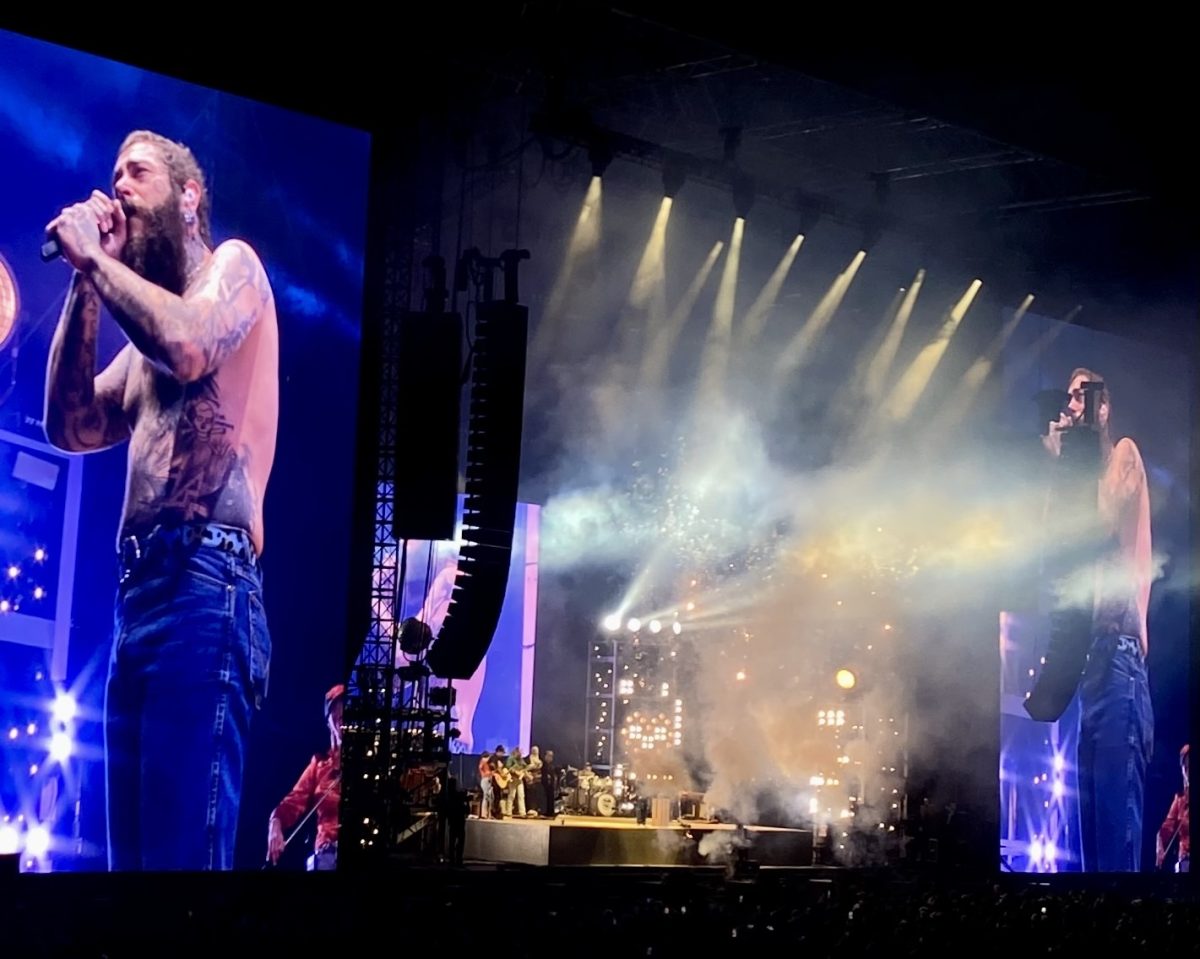 Post Malone sings into a microphone on stage at Nissan Stadium, as photographed on Oct. 19, 2024. (Hustler Multimedia/Sara West)