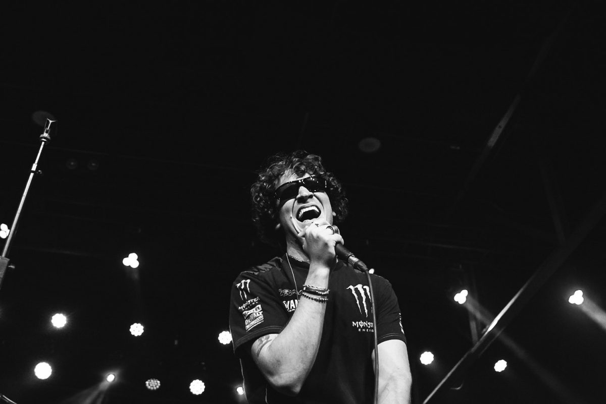 Ben Roter, lead vocals of Quarters of Change, wears sunglasses and sings into the microphone, as photographed on Oct. 3, 2024. (Hustler Multimedia/Nikita Rohila) 