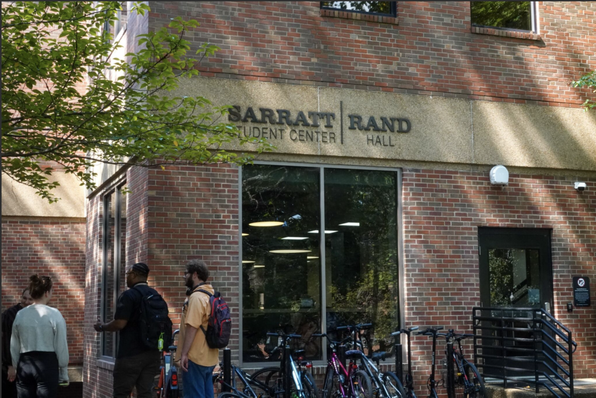 Students stand outside a side entrance of Rand Hall, as photographed on Sept. 9, 2025. (Hustler Multimedia/Emily Peng) 