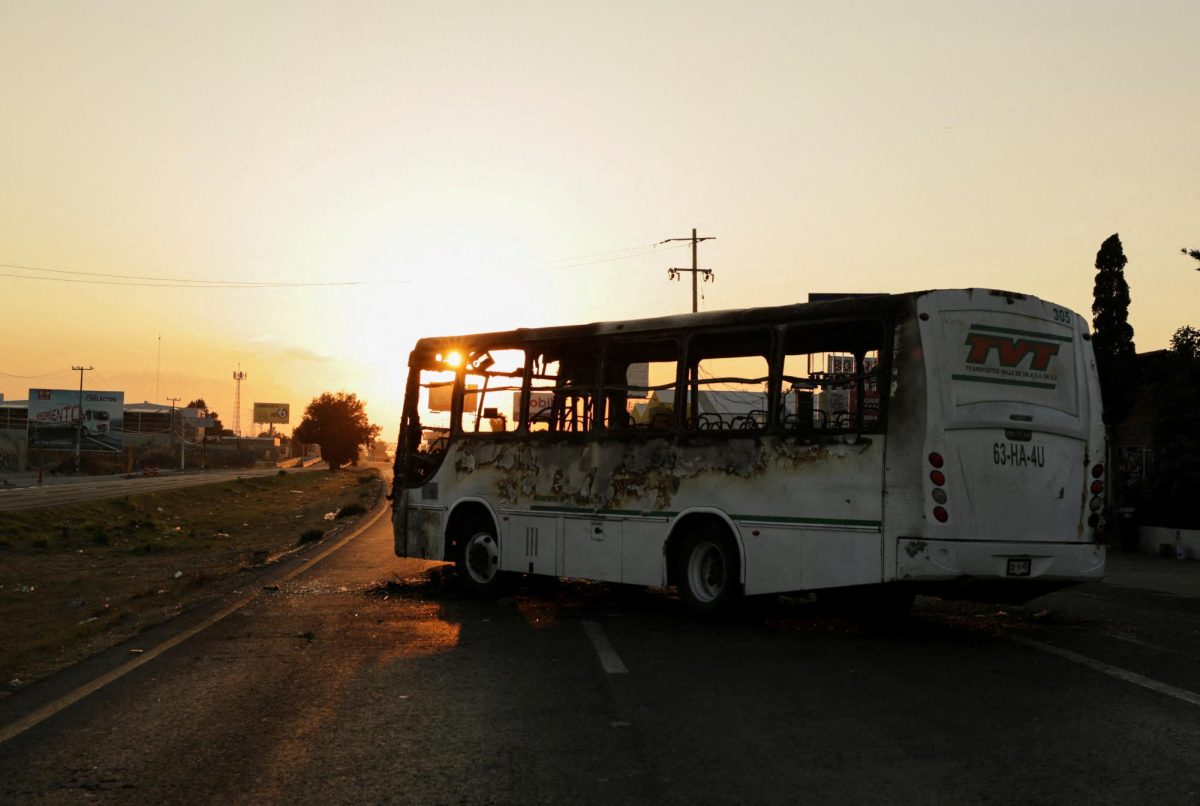 A burnt bus set up as a blockade by members of organized crime following a military operation at a tourist area in Zapopan, Mexico, February 22, 2026. REUTERS/Gabriel Trujillo