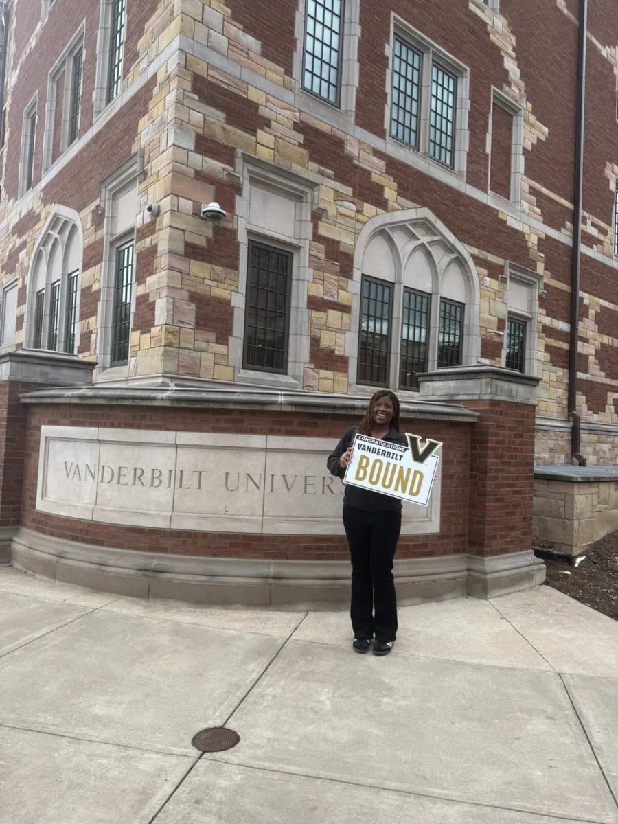 Brooklyn Reaves poses for a picture in front of Zeppos while holding a sign that says “Vanderbilt Bound.” (Photo Courtesy of Brooklyn Reaves)