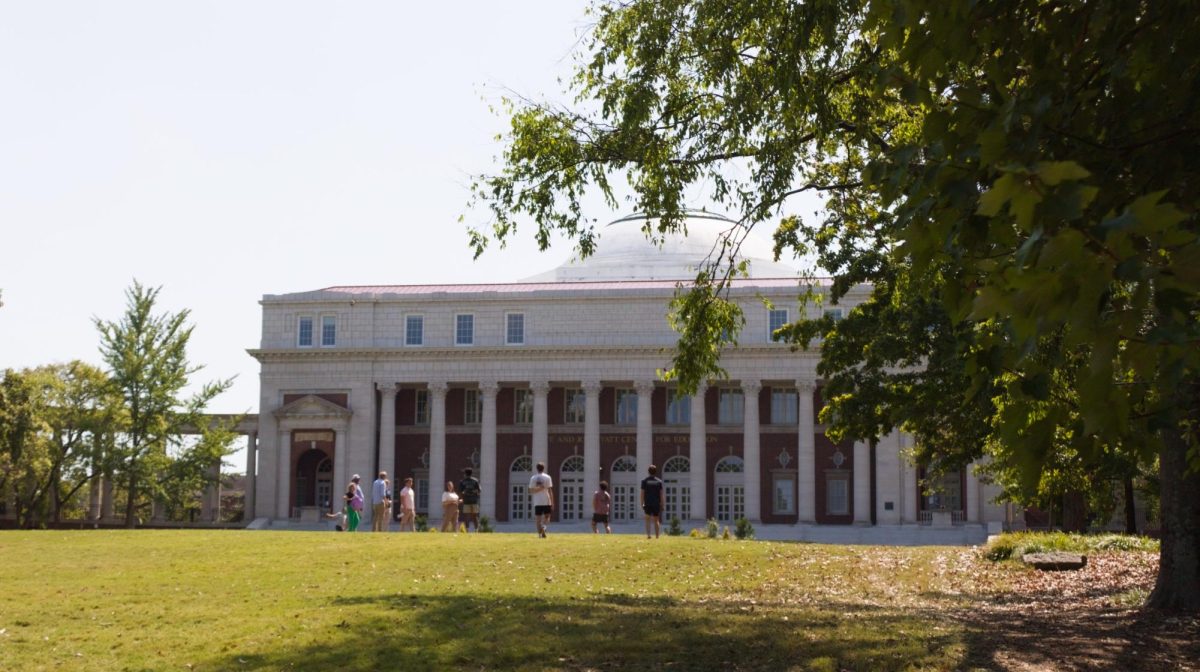 Wyatt Center on a sunny afternoon with students sitting in a circle on the lawn in the foreground, as photographed Sept. 13, 2025. (Hustler Multimedia/George Albu)