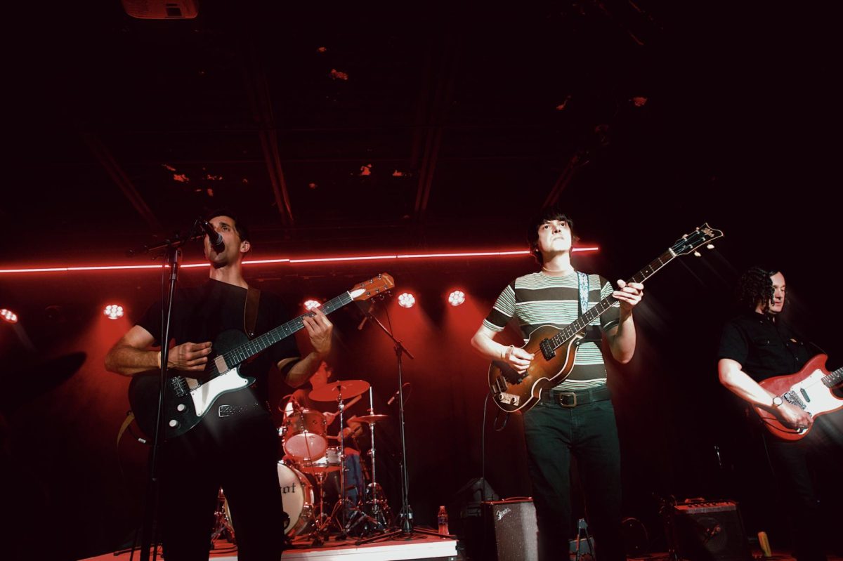 Lead singer Ramesh Srivastava strums the guitar and sings into the microphone, as photographed April 15, 2026. (Angel Akpovi/Hustler Multimedia)