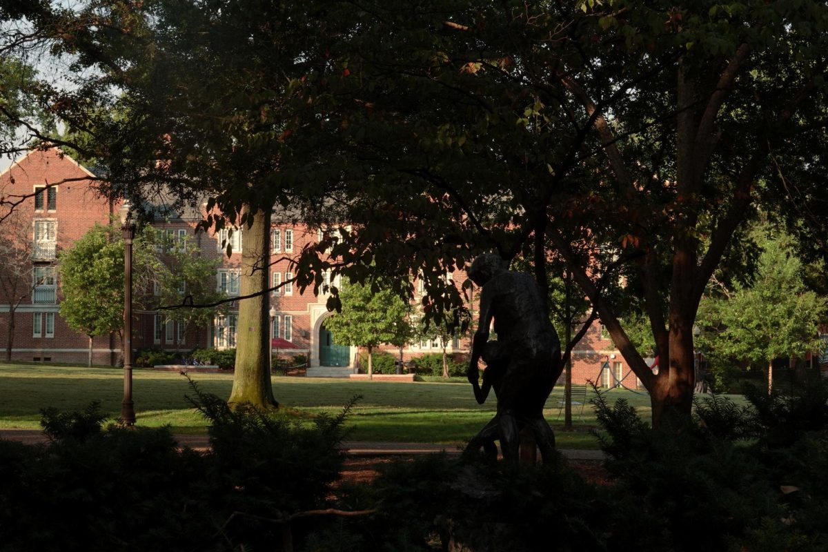 A view of Alumni Lawn from behind a statue and trees, as photographed Sept. 10, 2025. (Hustler Multimedia/Corey Lochan)
