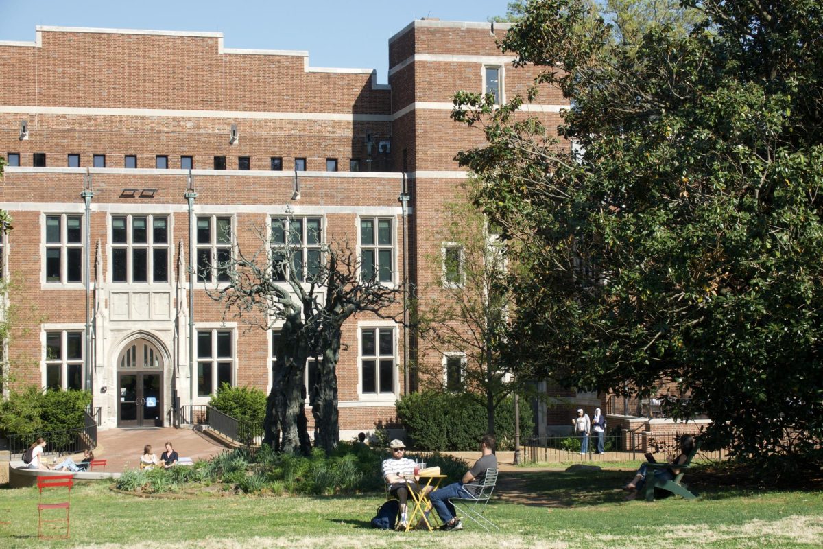 Two men sit on Library Lawn on a sunny day with Central Library in the background, as photographed April 14, 2026. (Hustler Multimedia/Meagan To) 