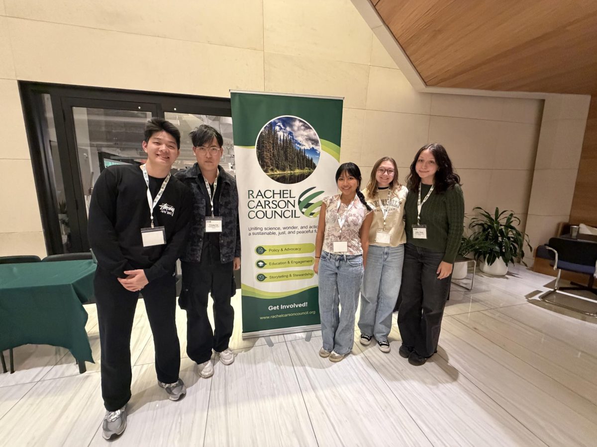 Ziheng Yan, Yisong Liu, Grace Park, Chloe Whalen and Adna Mutic (left to right) stand in front of a Rachel Carson Council poster, as photographed March 26, 2026. (Photo courtesy of Sydney O’Shaughnessy and the Rachel Carson Council)